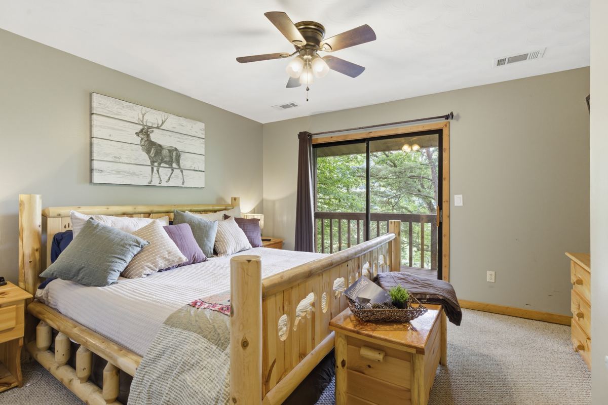 King bedroom with a log bed and a door to the balcony